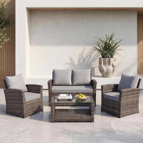 4 seater rattan garden sofa set with cushioned two-seater sofa, armchairs, and glass-top coffee table in modern outdoor patio setting